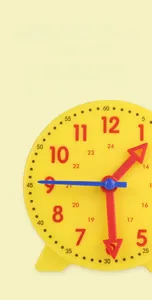Detailed macro of a yellow educational clock with red hands and 24-hour markers