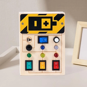 Detail of Montessori wooden busy board featuring colorful LED lights and toggle switches