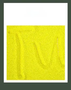 Gros plan de sable sensoriel jaune fluo pour tracer des lettres sur un plateau en bois