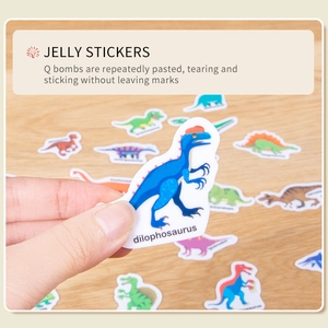 Reusable cartoon dinosaur jelly stickers for kids early education on a wooden table