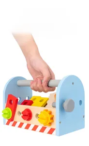 Macro shot of a child's hand holding a blue wooden tool box with colorful toy parts