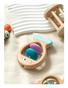 Detailed view of fish-shaped wooden rattle with smooth edges and colorful rotating beads