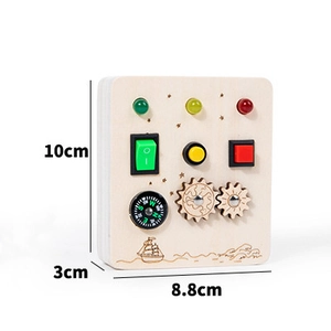 Detail view of wooden busy board toy showing LED lights, switches, and gears