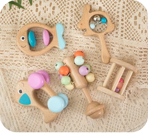 Close-up of five colorful wooden baby rattles set on a white lace tablecloth