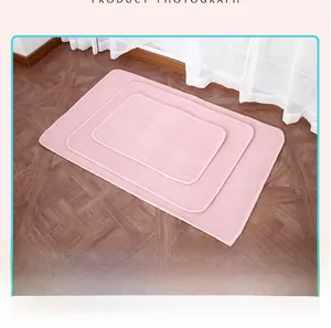 Set of three pink Montessori work rugs in various sizes on a dark wooden floor