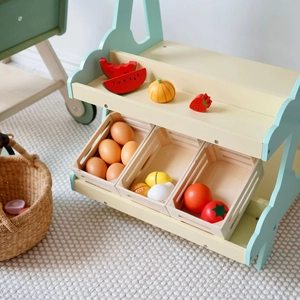 Detail eines Spielzeug-Supermarktregals aus Holz mit Obst- und Gemüsemodellen für Kinder