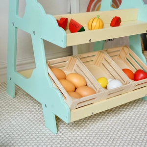 Details des Holz-Kaufladens mit mintgrünen Regalen und buntem Spielzeugobst für Kinder
