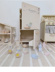 Detail view of wooden play refrigerator with realistic cream-colored miniature food toys