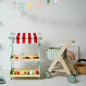 Detailansicht eines Spielmarktes aus Holz mit Einkaufswagen und Spielzeuglebensmitteln