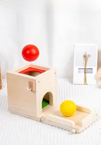 Close-up of Montessori wooden object permanence box with red and yellow balls for toddlers