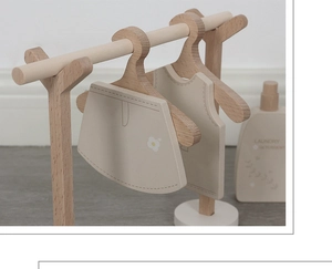 Close-up of wooden doll clothes hangers with floral dress, Nordic style play set detail