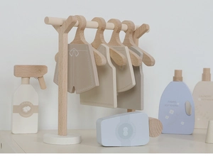 Macro view of Nordic style wooden laundry set featuring hangers and cleaning toy bottles