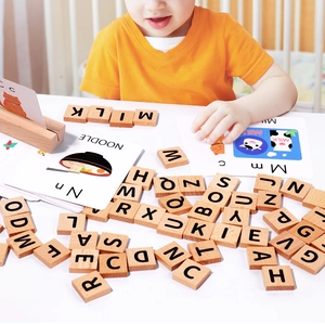 Macro view of child matching wooden alphabet blocks with English vocabulary cards