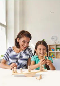 Close-up of mother and child playing with natural wooden balance blocks and peg dolls