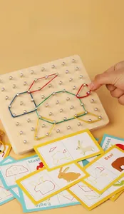 Close-up of wooden geoboard with colored rubber bands and educational pattern cards