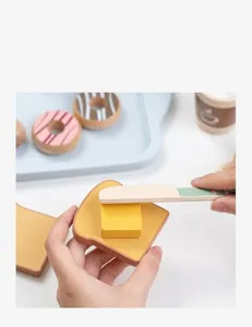 Detailed view of wooden play food set with toy bread, butter, and knife on a blue tray