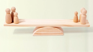 Macro detail of wooden rainbow stacking figures and balancing beam toys on cream background