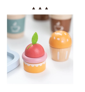 Detail of wooden play food set with colorful macaron cupcakes and felt leaf decoration