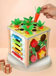 Detail of wooden activity cube featuring carrot pulling game and musical xylophone for kids