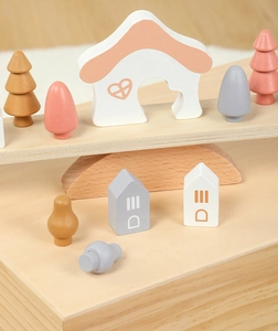 Macro detail of rainbow wooden balance blocks with miniature houses and tree shapes