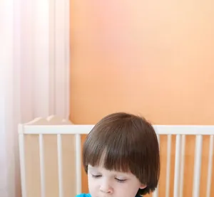 Toddler engaging with educational alphabet learning materials in a cozy nursery setting