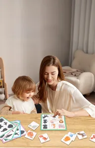 Close-up of mother and child playing with animal shadow matching wooden puzzle cards