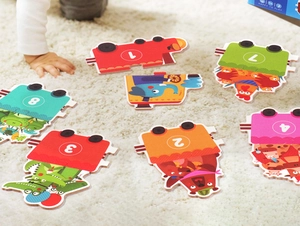 Detail of colorful number puzzle pieces with cartoon animals on a soft plush carpet