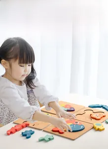 Toddler playing with chunky wooden animal puzzle on table for early learning skill development