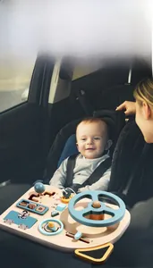 Close-up of wooden Montessori steering wheel busy board for toddler in a car seat