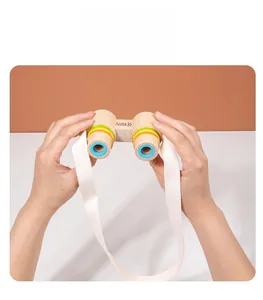 Dettaglio di un bambino che tiene il binocolo giocattolo in legno con anelli colorati
