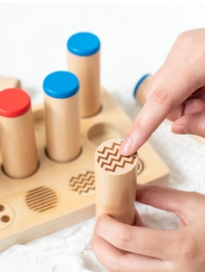 Macro view of wooden sensory cylinders with textured tops for tactile training