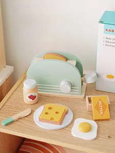 Detail of wooden toaster toy set including mint green toaster and breakfast accessories