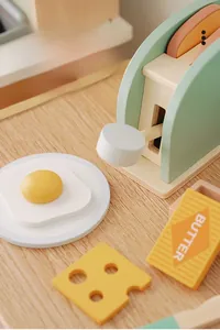 Close-up of wooden toaster toy set including toy egg, butter and cheese accessories