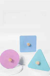 Dettaglio di puzzle geometrico in legno pastello con pomelli e bordi arrotondati