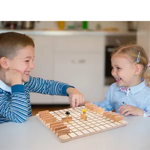 Two children playing a strategic wooden board game with grid base and vertical hurdles