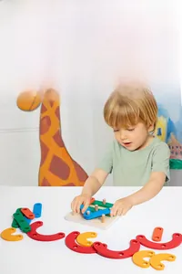 Kid playing with colorful wooden geometric sorting blocks on a natural wooden base