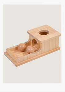 Detail of Montessori wooden object permanence box with smooth natural finish and two balls