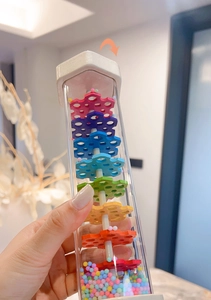 Macro detail of rainbow rainmaker showing colorful gears and tiny beads inside the tube