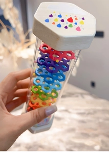 Detailed view of children's rainmaker toy with colorful beads and transparent cylinder