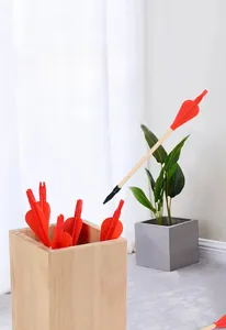 Close-up of traditional wooden pitch-pot game set with red feathered arrows in a modern home