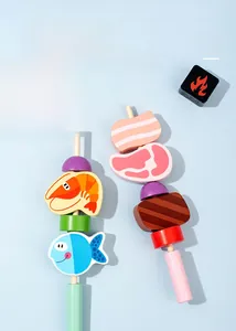 Close-up of wooden grill toy pieces including fish, meat, and shrimp on blue background