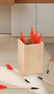 Traditional wooden pitch-pot game set with arrows and square wooden container indoors