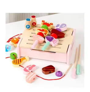 Close-up of pink wooden BBQ grill playset with various pretend food skewers and seasoning