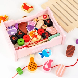 Detailed view of children's wooden BBQ toy set with assorted play food and pink tray