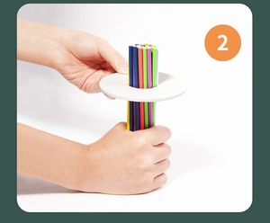Close-up of hands inserting colorful sensory wooden sticks into a white center-hole board