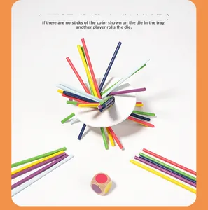 Detailed view of colorful wooden balance sticks and dice on a white circular tray