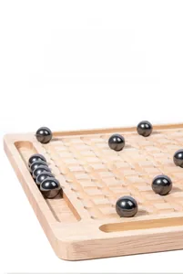 Detailed view of polished magnetic metal balls on natural wooden board with round slots