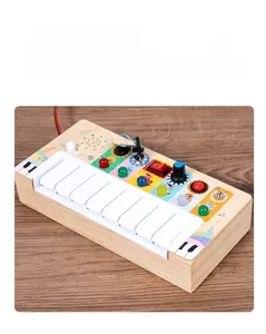 Detail view of wooden busy board with colorful piano keys and functional LED light switches