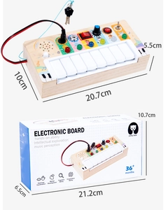 Detail of wooden busy board toy with piano keys and switches next to its colorful box