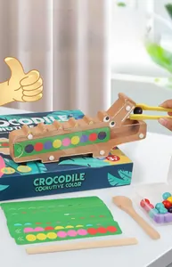 Macro detail of crocodile feeding game with colorful wooden beads and sorting tweezers